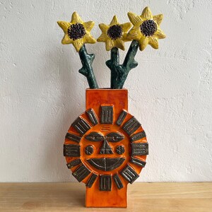 brutalistische orange vase fuer blumen