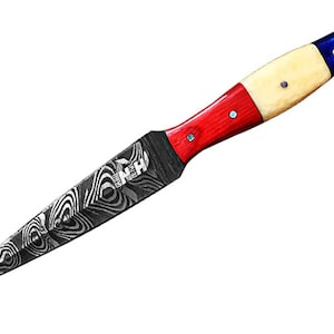 Könnte beinhalten: Ein dekoratives Messer mit gemusterter Klinge und einem Griff mit roten, weißen und blauen Abschnitten. Der Griff hat ein blaues Ende mit einem Stern und weißen Akzenten. Die Klinge hat ein einzigartiges Wirbelmuster.