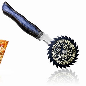 Könnte beinhalten: Ein Pizzaschneider mit einer schwarzen, kreisförmigen Klinge mit einem eingravierten Design und einem blau-schwarzen Holzgriff. Neben dem Schneider liegt ein Stück Pizza mit Peperoni und grünen Paprika.