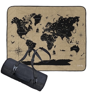 Könnte beinhalten: Beige Picknickdecke mit schwarzem Weltkarten-Design, Kompassrose und nautischen Illustrationen. Inklusive schwarzer Tragetasche mit Schultergurt. Die Decke ist zusammengerollt.