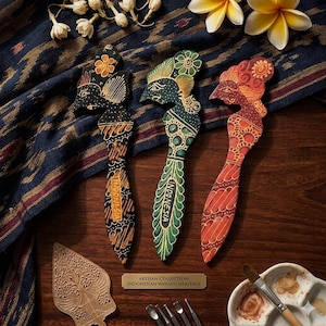 Può includere: Tre figure di legno indonesiane ispirate al Wayang in nero, verde e rosso, con intricati motivi in stile batik. Ogni figura ha un design unico e la parola "Indonesia" è scritta sul manico. Le figure sono esposte su una superficie di legno.