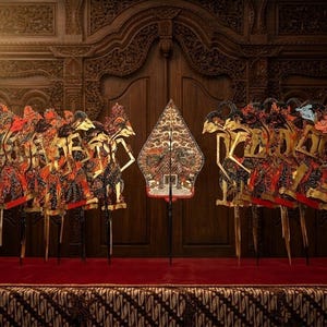 Puede incluir: Una colección de marionetas de sombra javanesas tradicionales, conocidas como wayang kulit, dispuestas en dos grupos con una pieza central gunungan o kayon. Las figuras de cuero planas e intrincadas presentan tallas detalladas en rojo, negro y oro.