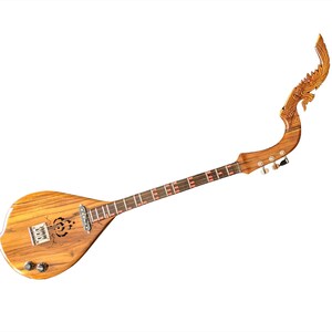 Puede incluir: Un phin tailandés de madera, un instrumento de cuerda pulsada, con un mástil curvo distintivo y tallado ornamentado en la parte superior. El cuerpo tiene una veta de madera marrón claro y el diapasón tiene detalles en rojo. El instrumento está sobre fondo blanco.