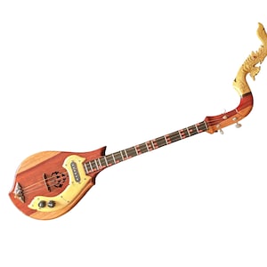 Puede incluir: Un Phin de madera, un instrumento de cuerda tailandés tradicional, con un mástil curvo con una cabeza de dragón tallada. El cuerpo es una mezcla de madera clara y oscura, con una boca decorativa y clavijas de afinación.