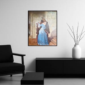 Puede incluir: Impresi&oacute;n enmarcada de una pintura que representa a una pareja abraz&aacute;ndose. La mujer lleva un vestido largo azul claro. El hombre lleva un abrigo y sombrero oscuros. El fondo presenta una pared de piedra y escaleras.