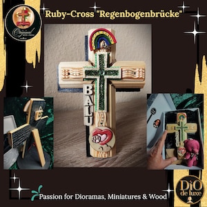 Könnte beinhalten: Ein Holzkreuz mit einem Regenbogenbogen an der Spitze, einem grünen, texturierten Mittelkreuz und einem Herz-Emblem mit Pfotenabdruck. Der Name BALU steht vertikal auf der linken Seite. Das Kreuz wird in einer Schachtel mit einem kleinen Plüschbären präsentiert.