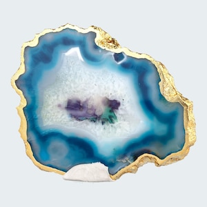 Könnte beinhalten: Eine blaue und weiße Agatscheibe mit goldener Umrandung. Der Achat ist ein Naturstein mit einem einzigartigen Muster und eignet sich perfekt für die Dekoration des Hauses.
