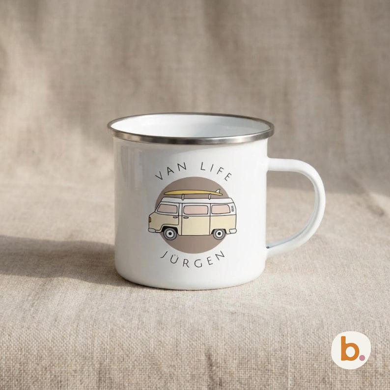 A white enamel mug features a yellow campervan illustration inside a brown circle and the custom name JÜRGEN.