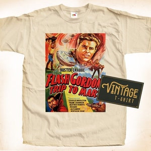 Könnte beinhalten: Ein Vintage-T-Shirt in Beige mit einem bunten Druck des Filmplakats für "Flash Gordon's Trip to Mars". Das Plakat zeigt Buster Crabbe und den Text "Vintage T-Shirt".