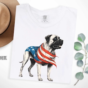 May include: White t-shirt with a graphic of a bulldog wearing an American flag bandana. The text "COMFORT COLORS" is printed on the tag.