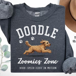 May include: Dark heather gray sweatshirt with the word "DOODLE" in white block letters above a running brown dog illustration. Below the dog is the text "Zoomies Zone" and "HIGH-SPEED FLUFF IN MOTION" in white script.