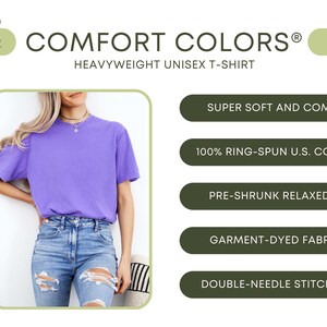May include: A purple, heavyweight unisex t-shirt made from 100% ring-spun U.S. cotton. The t-shirt is pre-shrunk and has a relaxed fit. It is garment-dyed and features double-needle stitching. The t-shirt is shown on a model wearing it with blue jeans.