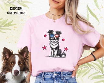 May include: A pink t-shirt with a cartoon border collie wearing sunglasses with the American flag design. The dog is surrounded by red stars.