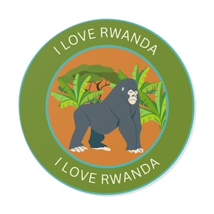 May include: A green circle sticker with the text "I Love Rwanda" around the edge. Inside the circle is a brown background with a green tree and a black gorilla standing on the ground.