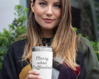May include: A white stainless steel tumbler with a silver lid and the text "Classy when Caffinated" in gray lettering.