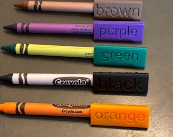 May include: A set of 10 Crayola crayons with color-coded labels. The colors are yellow, red, brown, purple, green, black, orange, and blue.
