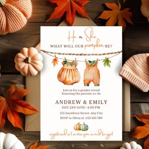 Puede incluir: Una invitación de revelación de género con el texto "He or She, What will our pumpkin be?" con ilustraciones de acuarela de ropa de bebé y calabazas. La invitación incluye los nombres Andrew & Emily, la fecha, la hora y la información de RSVP. El diseño está rodeado de calabazas, hojas y un gorro de punto.