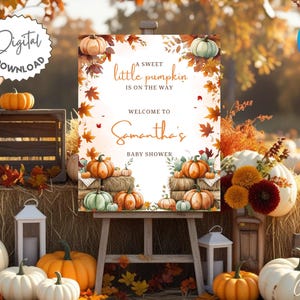 Può includere: Un cartello per baby shower con il testo "A sweet little pumpkin is on the way" e "Welcome to Samantha's Baby Shower." Il cartello presenta zucche ad acquerello e fogliame autunnale. L'immagine include zucche, balle di fieno e lanterne.