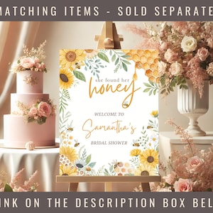 May include: A white bridal shower sign with a yellow honeycomb design and sunflowers. The text on the sign reads "She found her honey" and "Welcome to Samantha's Bridal Shower".