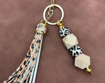 Tan animal print silicone beads and long tassel plus wooden hexagon beads on gold hardware with gold post keychain/zipper pull.