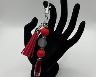 Mini red pen with black ink has clip and red tassel with gun metal rhinestone spacers.  Matte red silicone & translucent silver gray resin