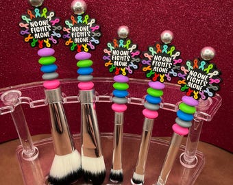 Set of 5 “No one Fights Alone” focal bead makeup brushes, numerous color silicone beads with silver stems. We all know someone!