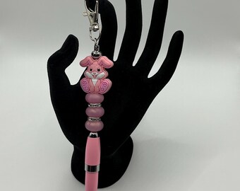Silicone pink bunny rabbit pen keychain with pink casing and pink shimmering silicone beads and rhinestone spacers.