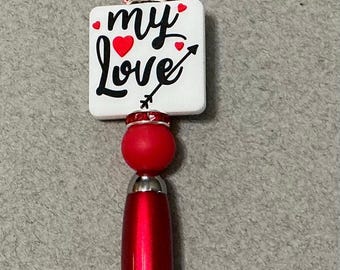 Black & white “My Love” with red hearts + round red silicone beads on metallic red pen casing with black ink + red rhinestones + clip.