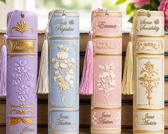 May include: Four rectangular bookmarks featuring embossed floral designs and gold-colored accents. Each bookmark displays a Jane Austen book title: Persuasion, Pride & Prejudice, Emma, and Sense & Sensibility, with a matching colored tassel attached.
