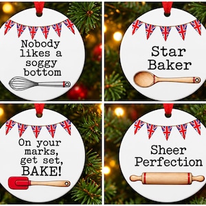 May include: Four round white ceramic ornaments with red ribbon hangers. Each features Union Jack bunting and baking-themed illustrations: a whisk with "Nobody likes a soggy bottom," a wooden spoon with "Star Baker," a spatula with "On your marks, get set, BAKE!," and a rolling pin with "Sheer Perfection."