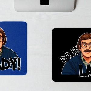 May include: Two rectangular mousepads, one blue and one black, each featuring a cartoon image of a man with glasses and a mustache. The text "DO IT LADY!" is printed on each mousepad.