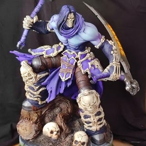 May include: A detailed, hand-painted figurine of a skeletal figure with a purple robe and a large scythe. The figure is standing on a tree stump base with skulls scattered around it.