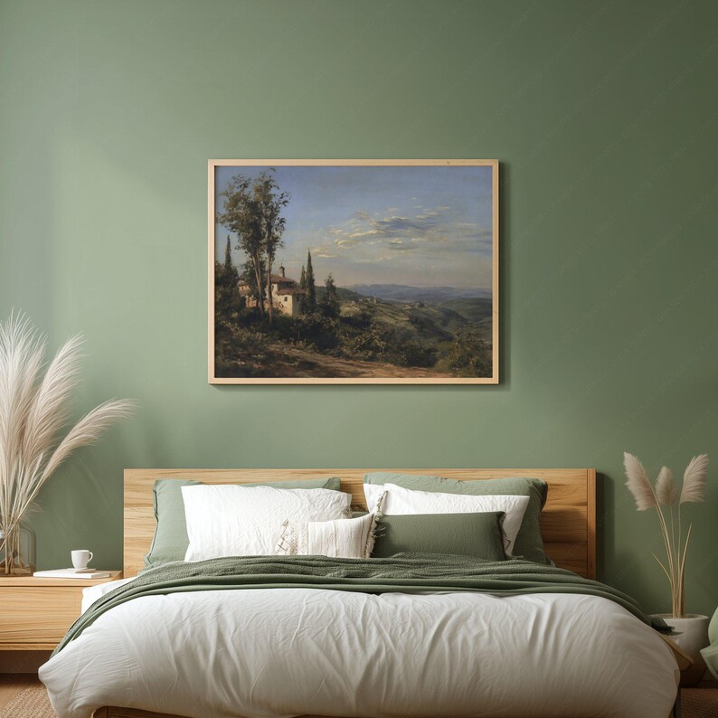 May include: A framed landscape painting depicts a Tuscan scene with a villa, cypress trees, and rolling hills under a blue sky. The artwork is displayed above a bed with white bedding and green pillows, creating a serene bedroom setting.
