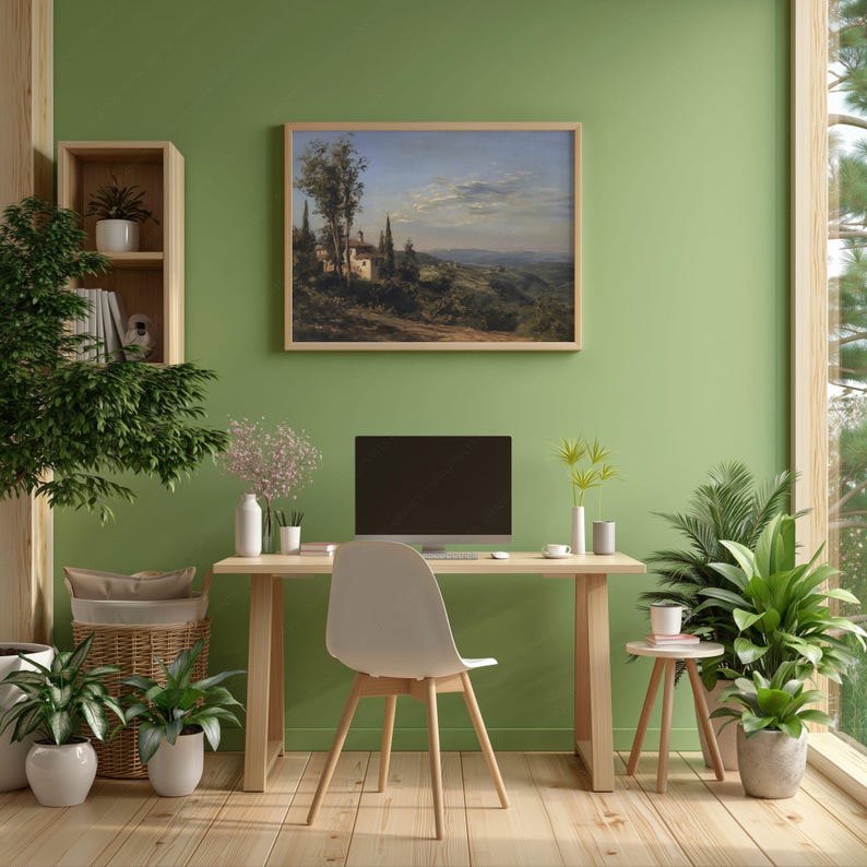 May include: A home office with a landscape painting, desk, and chair. The painting depicts a rural scene with buildings and trees. A computer monitor sits on the desk. Potted plants and a wooden floor complete the room.