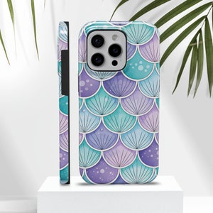 May include: A phone case with a mermaid scale pattern in shades of purple, blue, and green. The case has a cutout for the camera lens.