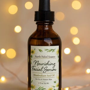 May include: A brown glass bottle of facial serum with a black dropper. The label reads "Nourishing Facial Serum" and "Meadowfoam Seed Oil" for dry and mature skin. The bottle contains 1.75 oz of product.