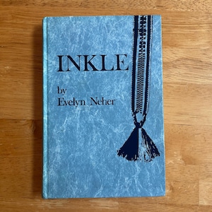 May include: A hardcover book titled INKLE by Evelyn Neher with a light blue, marbled-texture cover. The front cover features dark blue text and a graphic illustration of a woven band with a decorative tassel hanging from the bottom right side.