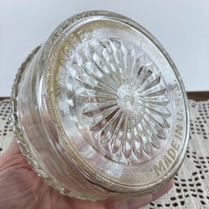 May include: Clear glass bowl with a decorative, starburst-patterned base. The bowl's rim has a textured design. The words "MADE IN U.S.A." are visible on the base. The bowl is likely vintage.
