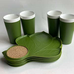 May include: Set of four green and white cups with a leaf-shaped green serving tray and a cork coaster.