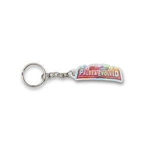 May include: A keychain with a silver ring and chain, connected to a holographic charm. The charm displays the text "Scarlet & Violet Paldea Evolved" in a colourful, stylised design. The keychain is likely a collectible item.