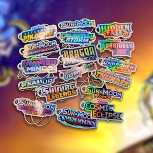 May include: A selection of holographic keyrings with different text designs. The keyrings display phrases such as "Pikachu," "Celestial Storm," and "Dragon Majesty." Each keyring has a silver ring.