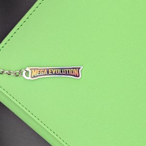 Puede incluir: Una cartera verde con una cadena plateada y un dije metálico que dice "MEGA EVOLUTION" en una fuente estilizada. La cartera tiene una superficie texturizada y un borde cosido.