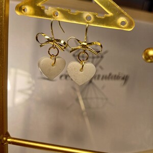 Boucles d'oreilles nœud Blanc irisé