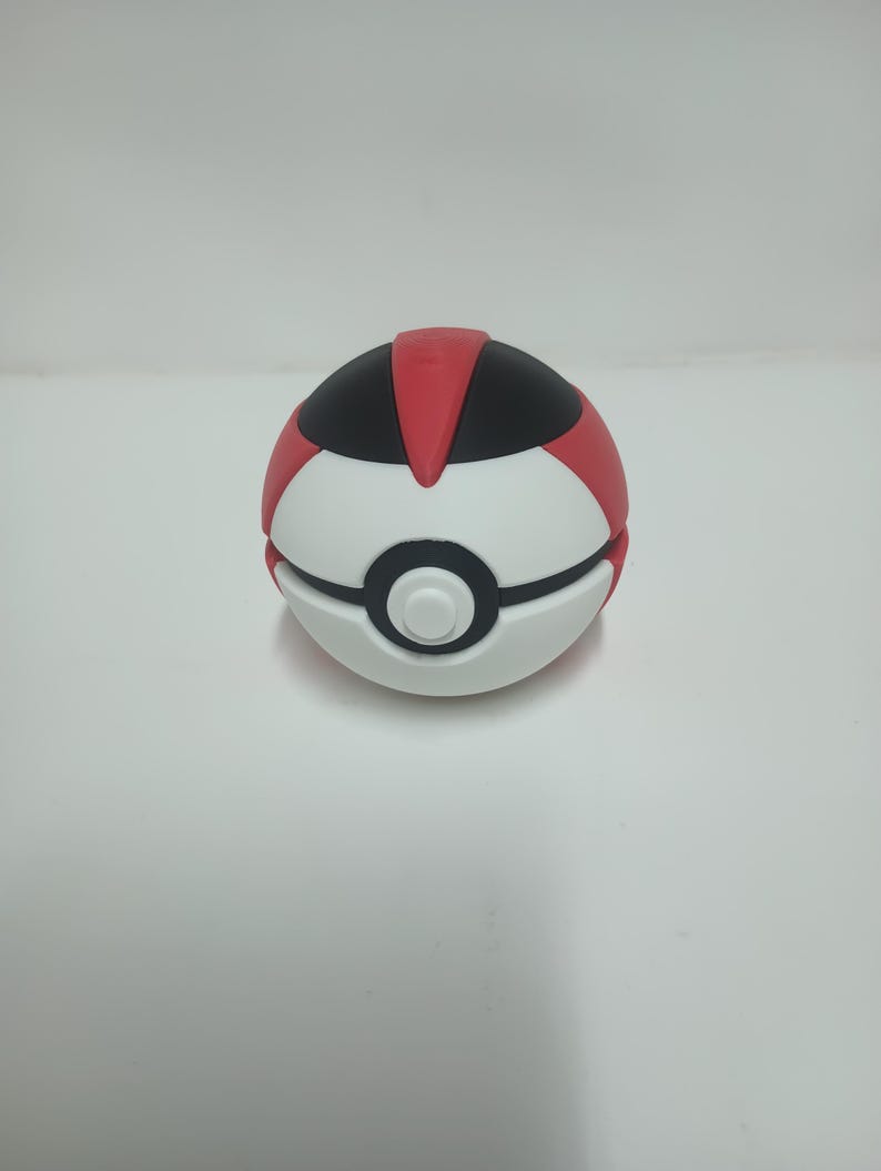 May include: A white, red, and black Pok&eacute; Ball. The top section is red and black, with a white center and a black band. The button is white. This collectible item is a popular choice for fans of the animated series.