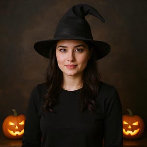 May include: A person wearing a black witch hat and black long-sleeved top, with two carved pumpkins with glowing orange faces. The background is a dark brown. Halloween theme.