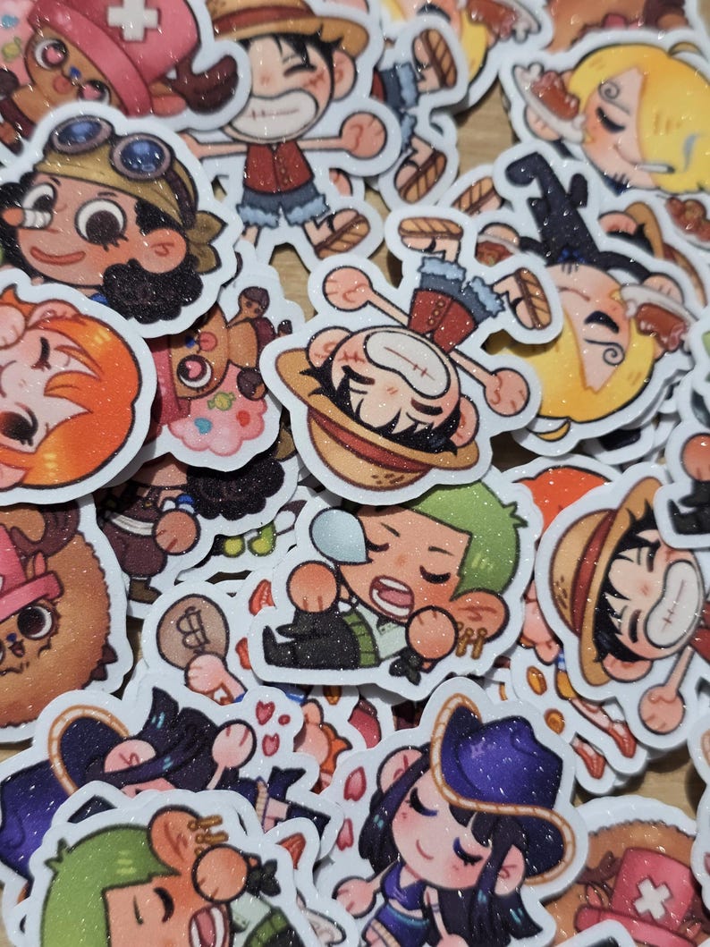 Op de afbeelding: Een verzameling kleurrijke cartoonkarakterstickers. De stickers tonen verschillende personages met verschillende gezichtsuitdrukkingen en outfits. De stickers hebben een glitterafwerking en zijn waarschijnlijk voor decoratieve doeleinden.