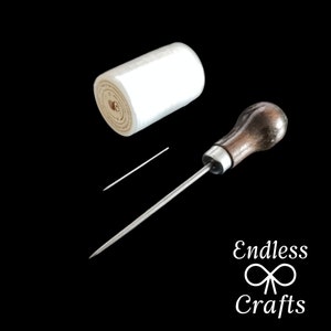 May include: A white roll of waxed thread, a leather sewing awl with a wooden handle, and a small needle.