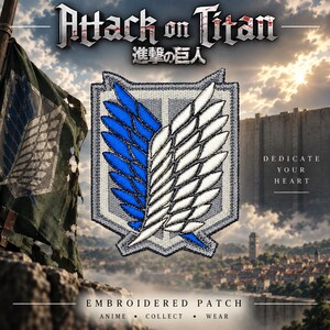 May include: An embroidered patch featuring the Wings of Freedom emblem from Attack on Titan. The design displays a shield shape with a split background of blue and white feathers, bordered by a thick grey stitched edge, centered on a background.
