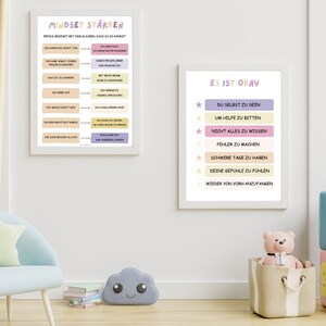 Könnte beinhalten: Zwei Motivationsposter mit positiven Affirmationen auf Deutsch. Das erste Poster ist rosa und lila und sagt "Mindset stärken" und das zweite Poster ist gelb und lila und sagt "Es ist okay".