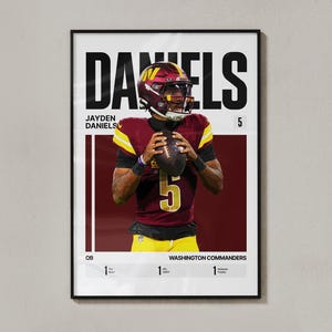 May include: A framed sports poster featuring Jayden Daniels of the Washington Commanders in a burgundy and gold uniform, holding a football. The text includes DANIELS, JAYDEN DANIELS, 5, QB, WASHINGTON COMMANDERS, and stats for Pro Bowl, NFL OROY, and Heisman.